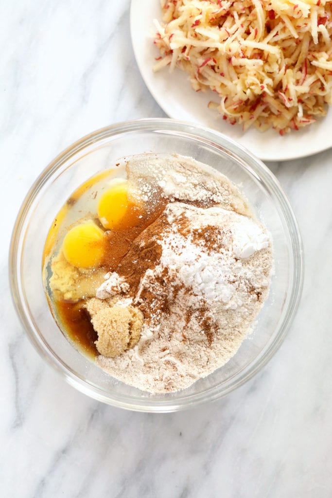 These Whole Grain Apple Cinnamon Pancakes made with whole wheat flour, grated apple, ground cinnamon, and coconut oil. ingredients in bowl