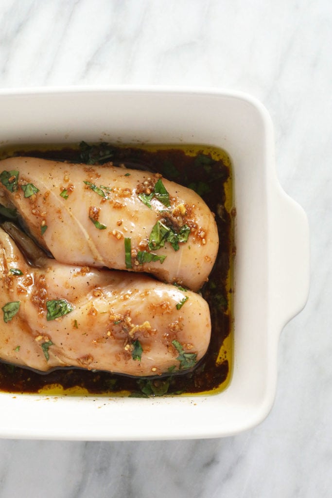 Raw chicken marinating in a pan. 