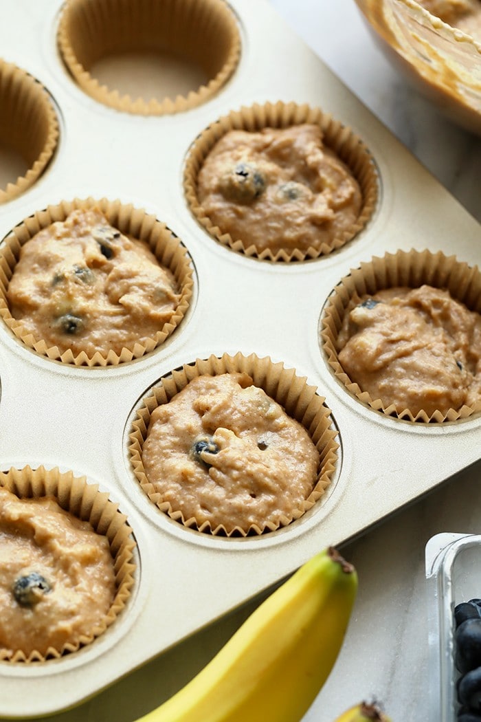 Who doesn't love blueberry muffins? These healthy blueberry muffins are easy to whip up for a picnic or a great healthy snack that the whole family will enjoy! Muffin liners with batter in them