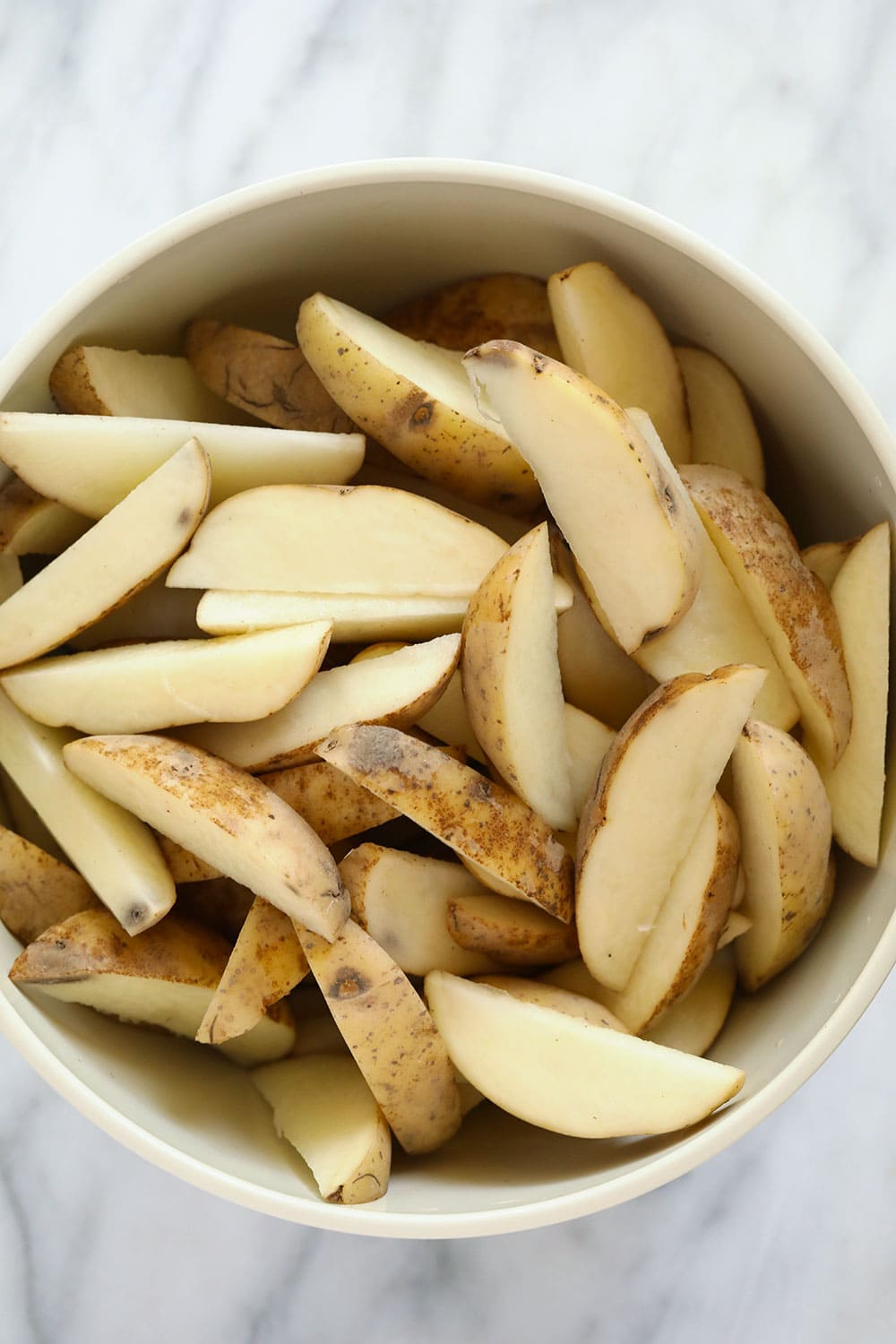Chopped potato wedges in a bowl.