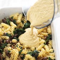 Pouring vegan pasta sauce into a casserole dish