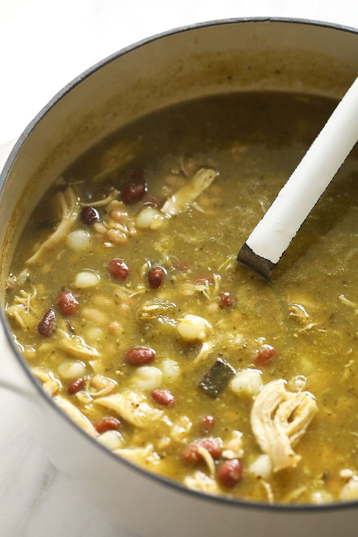 Green Chili (AKA Chile Verde) never looked so good! This easy green chicken chili is made with roasted peppers, your favorite salsa verde, chicken breast, and white beans. green chili in stock pot with ladle