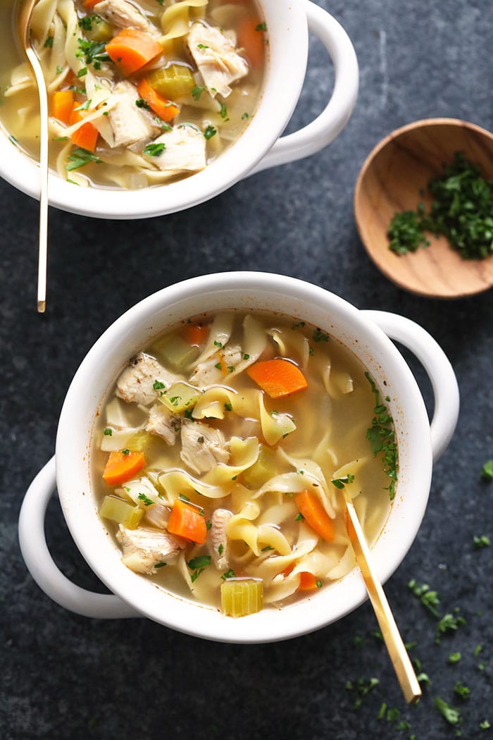 The internet's #1 slow cooker chicken noodle soup is made with lean chicken breast, hearty veggies, egg noodles, and broth. soup in bowl with spoon