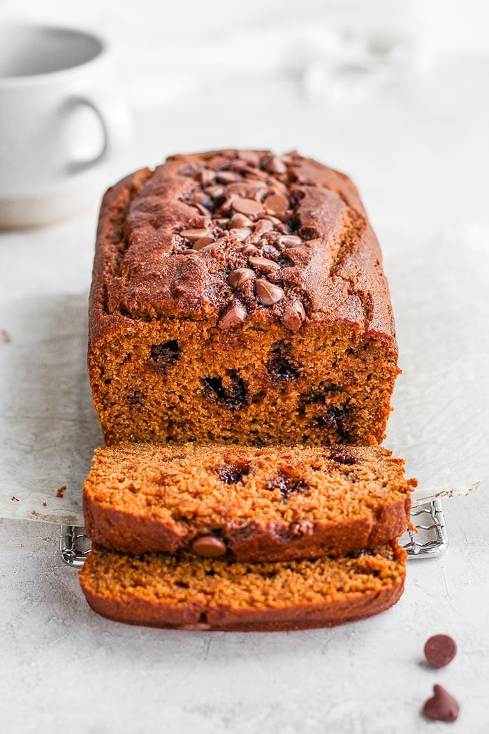 It’s pumpkin season! Which means it’s time to make this moist and flavorful Healthy Pumpkin Bread. Packed with pumpkin puree and a few chocolate chips + the just right amount of cinnamon, nutmeg, cloves and ginger, this pumpkin bread is something your whole family will enjoy! healthy pumpkin bread loaf sliced