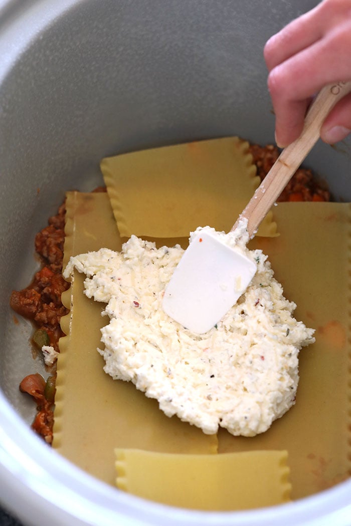 Make tonight Italian night with this amazing crockpot lasagna! This lasagna is made with a flavorful meat sauce, a delicious cheese mixture, and is super easy to make. Make it for the family tonight or meal prep it for the week! Spreading cheese mixture on lasagna noodles