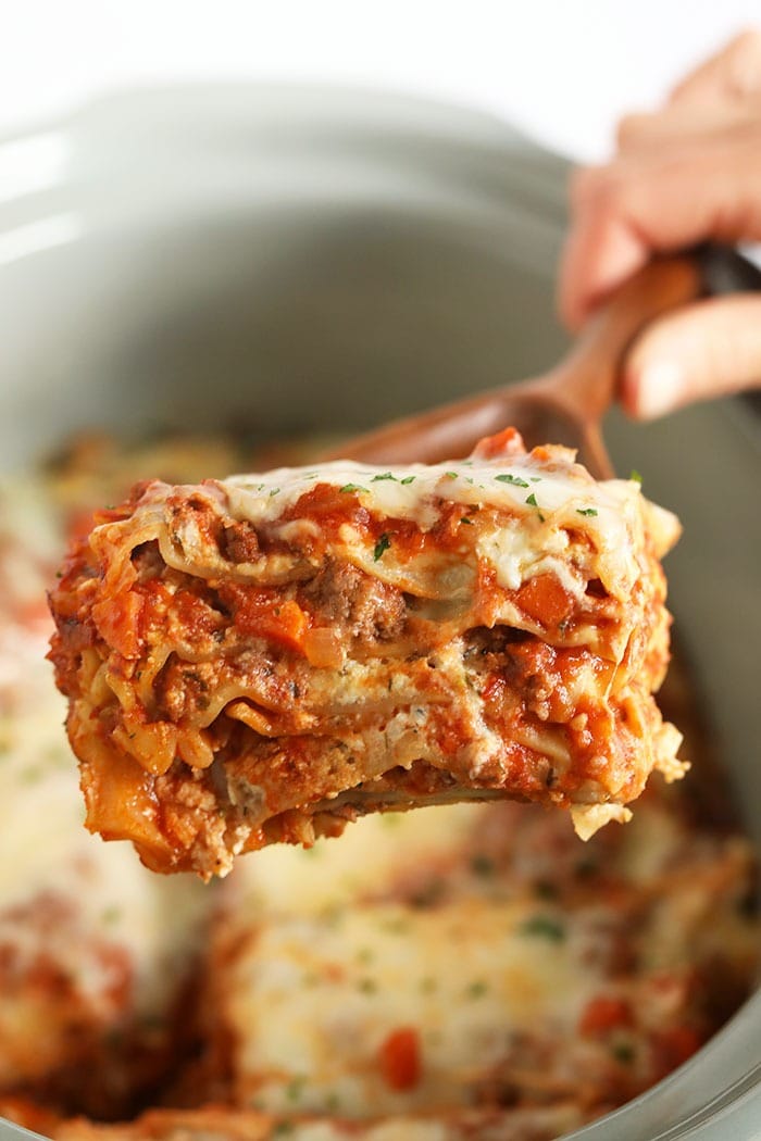 Make tonight Italian night with this amazing crockpot lasagna! This lasagna is made with a flavorful meat sauce, a delicious cheese mixture, and is super easy to make. Make it for the family tonight or meal prep it for the week! A piece of lasagna on a spatula