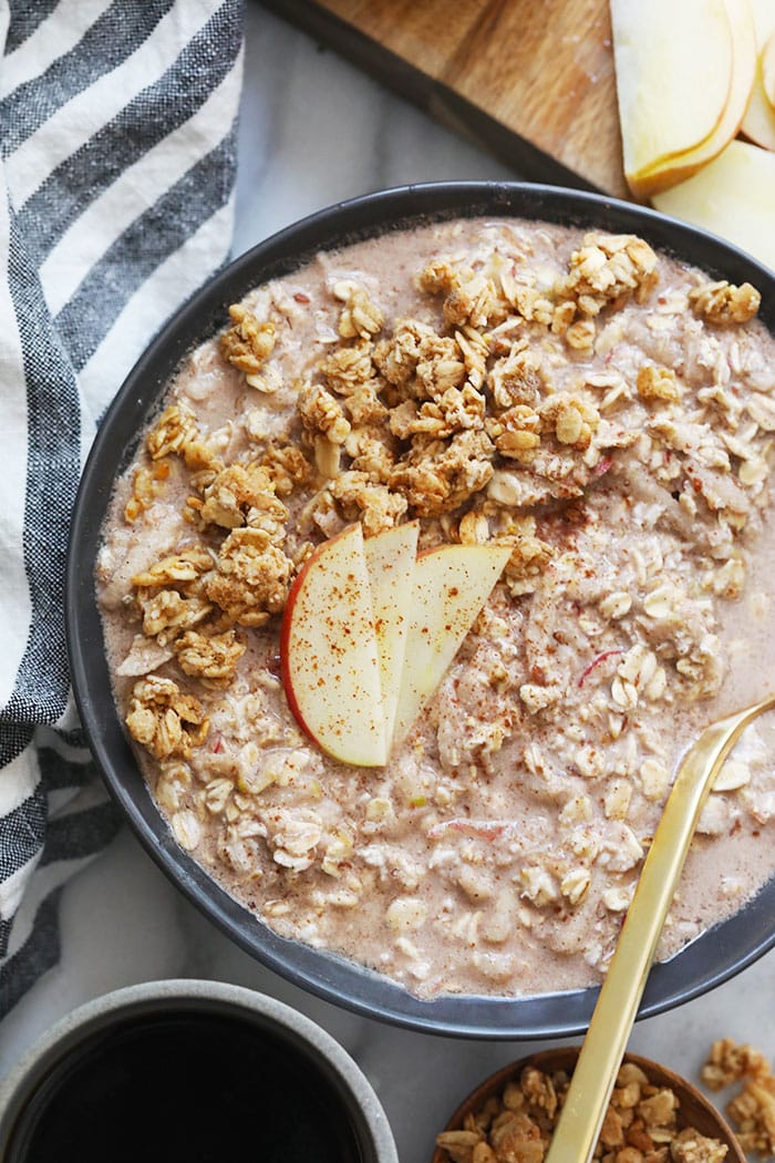 These Apple Cinnamon Overnight Oats will have you eating dessert for breakfast while getting a serving of whole grains and tons of protein at the same time. Prepare this overnight oats recipe the night before and you have an easy breakfast waiting for you in the morning! apple cinnamon overnight oats in a bowl topped with apple slices