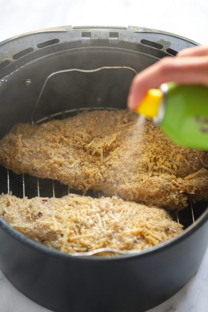 This air fryer chicken parmesan takes no time to whip up and only requires 5 main ingredients. Bonus - there is no oil involved! spraying chicken parmesan with cooking spray