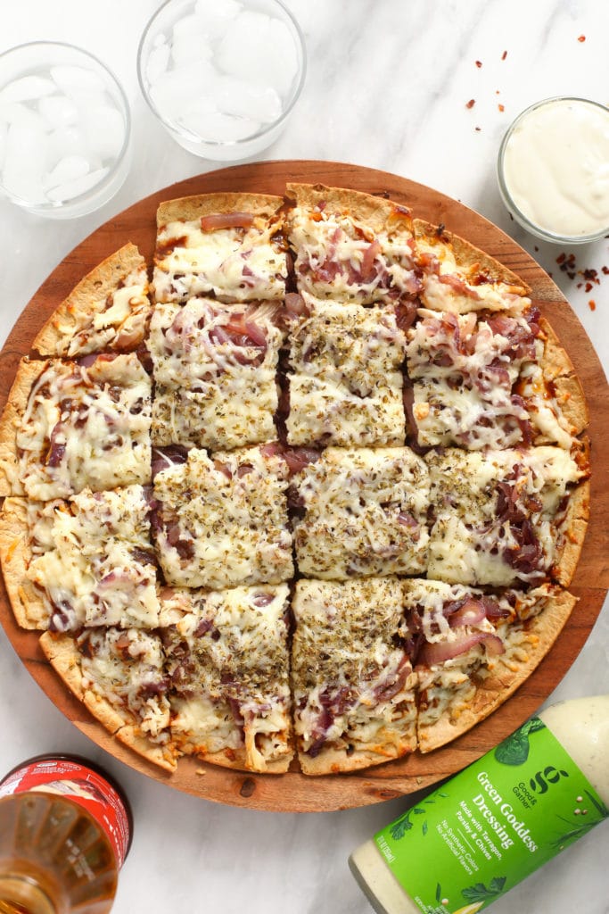 This BBQ chicken pizza with caramelized onions is ready in under 30 minutes and you only need 5 ingredients. It is saucy, flavorful, and makes Friday night pizza night as easy as can be! bbq chicken pizza sliced into squares