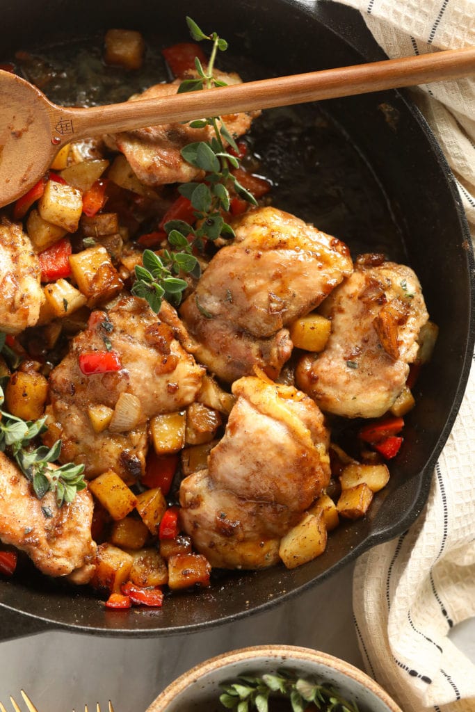 This Skillet Chicken and Potatoes is the perfect easy weeknight meal! With savory fall veggies and deliciously seasoned chicken thighs, this recipe will quickly become a staple in your kitchen! skillet chicken and potatoes looking so delicious in a cast iron skillet