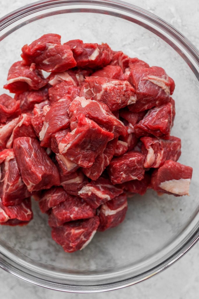 This Instant Pot Beef Stew is everything slow roasted stew is, but without the long cook time! Fall apart beef and tons of veggies, plus its ready to eat in under an hour. chunks of beef chuck ready to be prepped for beef stew