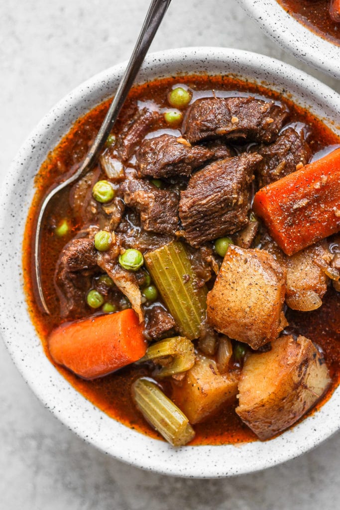 This Instant Pot Beef Stew is everything slow roasted stew is, but without the long cook time! Fall apart beef and tons of veggies, plus its ready to eat in under an hour. instant pot beef stew in a bowl with a spoon