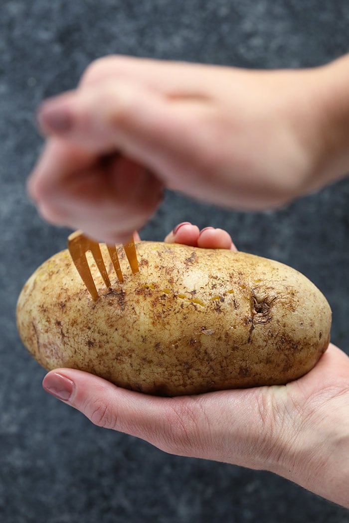 The easiest way to make perfect baked potatoes is in the crock pot! These Crock Pot Baked Potatoes are truly a set it and forget it recipe, leaving precious space in your oven to bake other recipes you're making. crock pot baked potato being speared with a fork