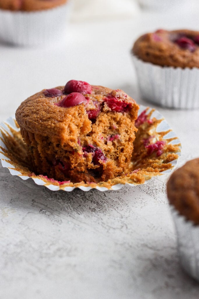 These Cranberry Orange Muffins are bursting with all those seasonal flavors you love! Made from healthy ingredients, including fresh cranberries and orange zest. Enjoy! cranberry orange muffin with a bite taken out of it
