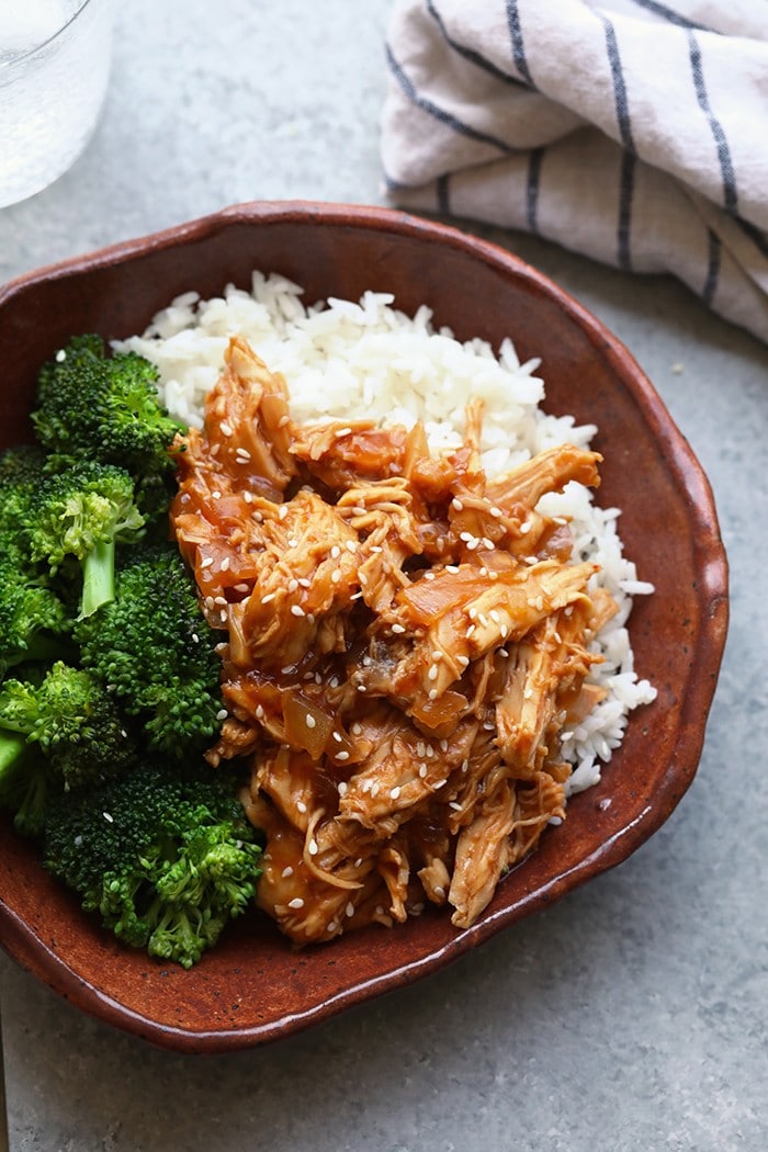 Throw all of the ingredients for this Healthy Crockpot Sesame Chicken recipe into your slow cooker and have dinner ready in no time. This healthy crockpot chicken recipe is kid-friendly, gluten-free friendly, and an excellent meal prep chicken recipe. crockpot sesame chicken in bowl
