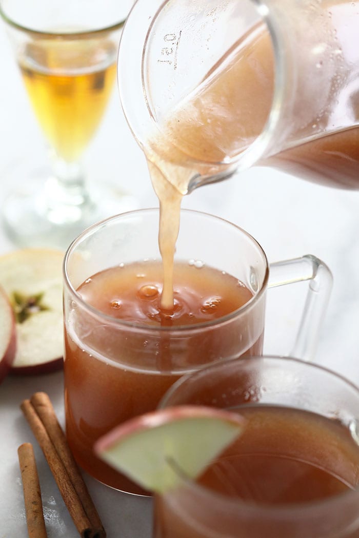 This Spiked Apple Cider is a boozy twist on our traditional apple cider recipe that’s been a Fall favorite for years. Make a large batch to serve a crowd, or pour a single serve spiked cider tonight. Cheers! spiked apple cider being poured in a glass