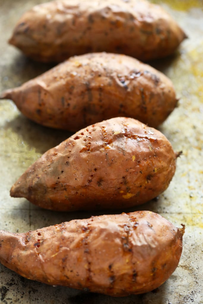 Baked sweet potatoes are a delicious addition to any meal. In this post, we'll teach you how to bake sweet potatoes in 3 easy steps and how to flavor and re-purpose your oven baked sweet potatoes! baked sweet potatoes on baking sheet with holes in them