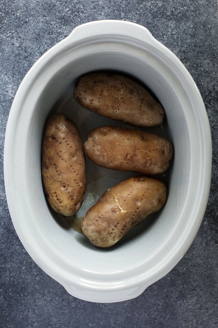 The easiest way to make perfect baked potatoes is in the crock pot! These Crock Pot Baked Potatoes are truly a set it and forget it recipe, leaving precious space in your oven to bake other recipes you're making. baked potatoes in the crock pot