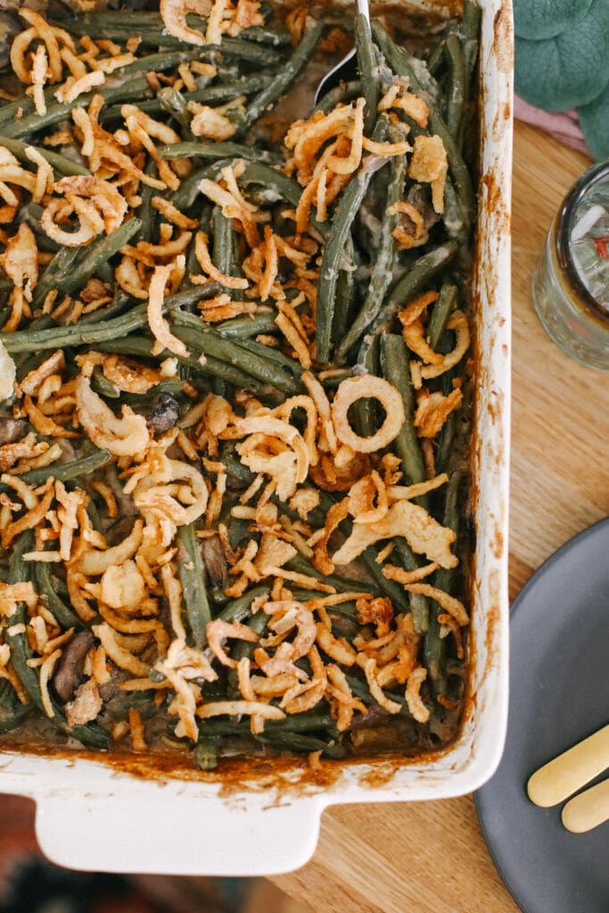Say hello to the most delicious vegan green bean casserole recipe on the internet. This vegan green bean casserole is made with fresh green beans, mushrooms, a vegan roux, and fried onions! green bean casserole on table