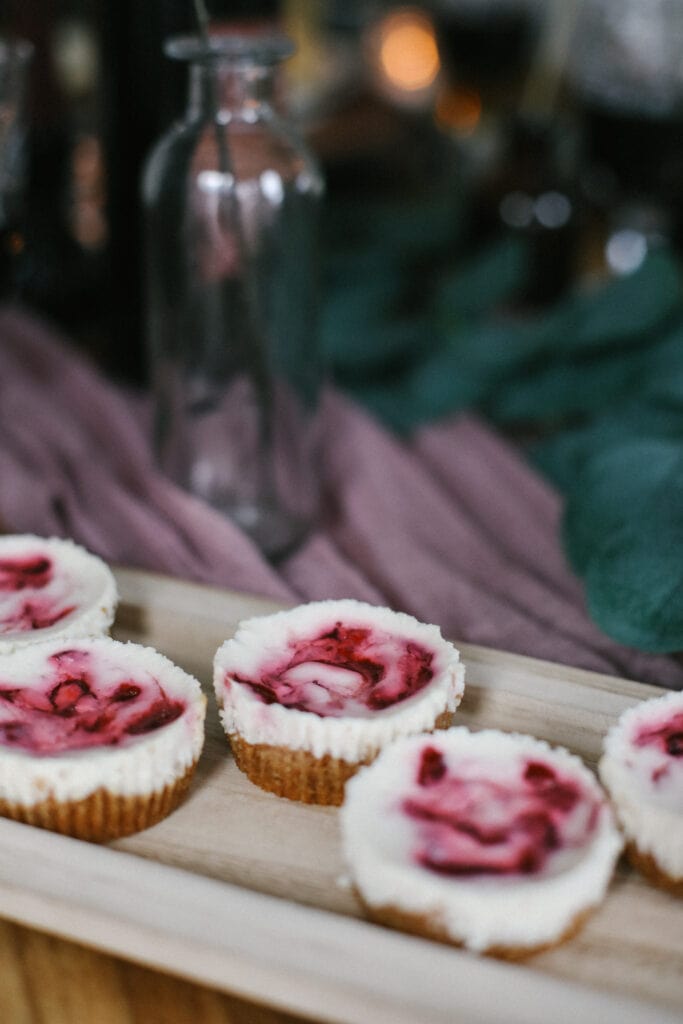 The most delicious, guilt-free dessert recipe made with a graham cracker crust, Greek yogurt cheesecake filling, and a cranberry sauce swirl! mini cheesecakes