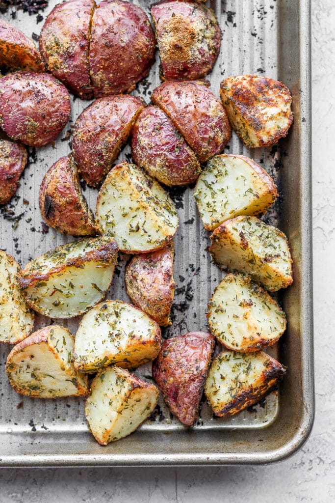 These Ranch Roasted Potatoes are flavor-packed and deliciously crispy! Whip up a batch for the most flavorful side dish. roasted red potatoes on a baking sheet looking crispy and delicious