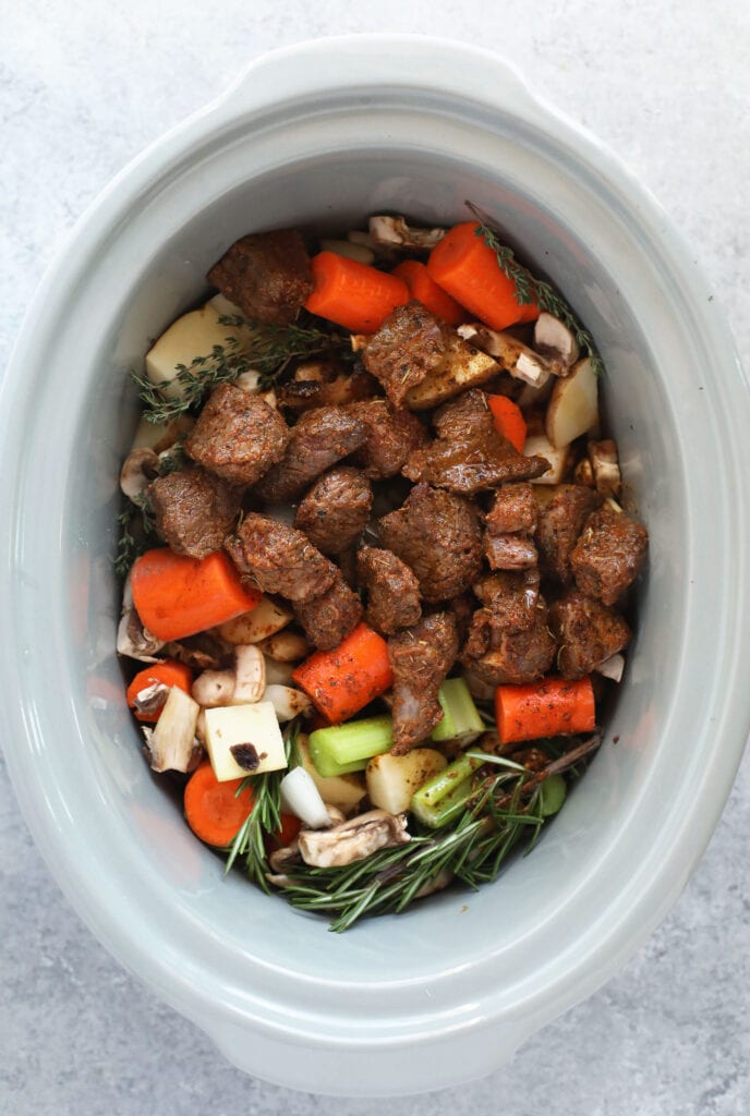 This is the most tender and flavorful Slow Cooker Beef Stew you'll ever have! Fall apart beef and tons of veggies make this beef stew the perfect (and healthy!) cozy comfort meal. fresh ingredients for beef stew in the slow cooker