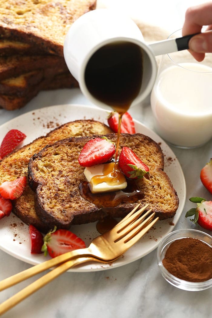 This Sheet Pan French Toast is the answer to your brunch dreams! It's ready to serve in under 30 minutes, and can easily be doubled to serve a crowd. Happy brunching! sheet pan french toast on a plate drizzled with maple syrup