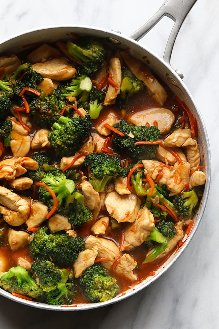 This chicken stir fry recipe is made with chicken breast, broccoli, and carrots, and the sauce is made with fresh ginger, soy sauce/tamari, honey, and sriracha. chicken stir fry in pan