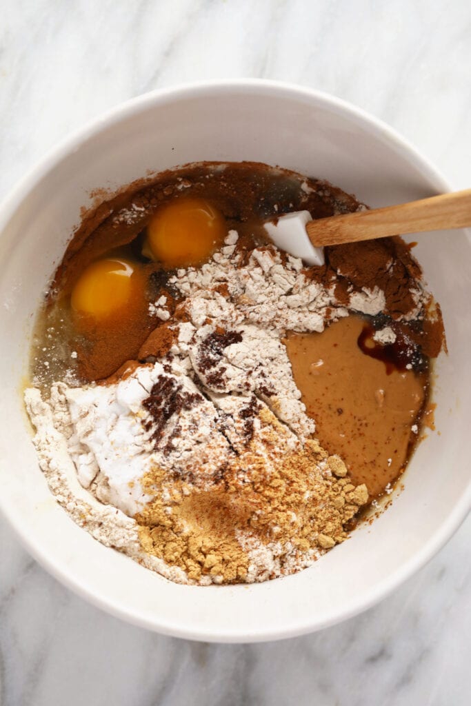 These Gingerbread Cookie Bars are the perfect festive sweet treat! Whip up a batch, and you'll be biting into these deliciously chewy bars in under an hour. Enjoy! gingerbread cookie bar ingredients in a bowl