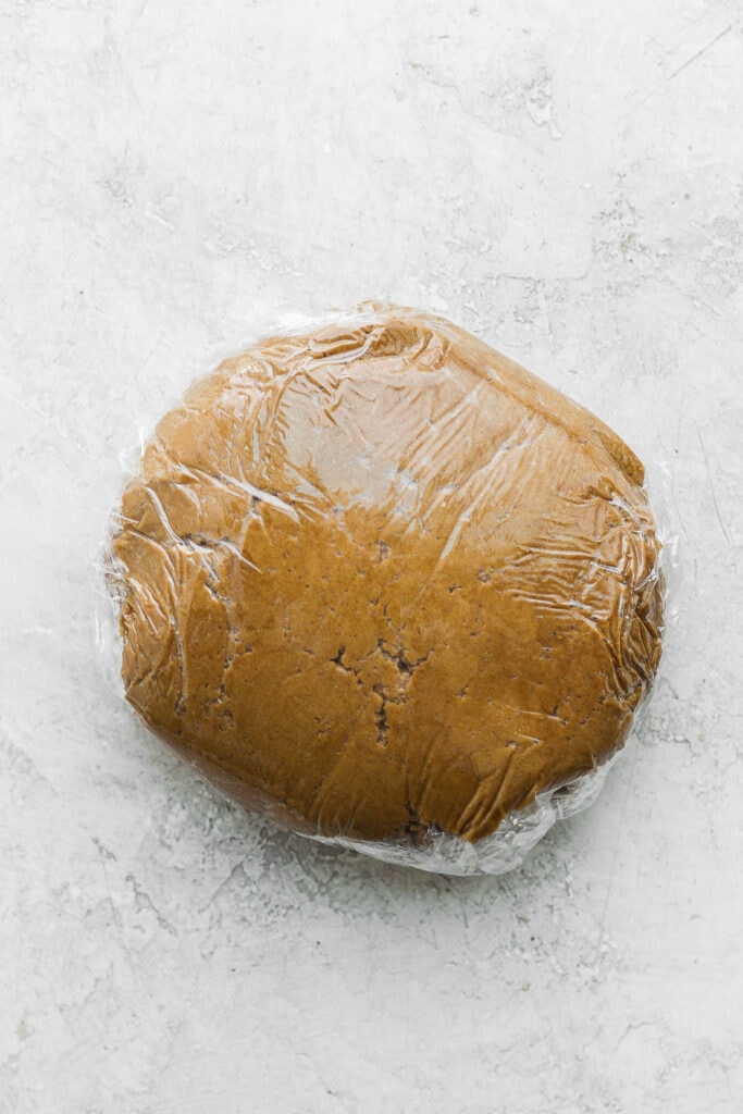 Gingerbread cookie dough wrapped in plastic wrap.