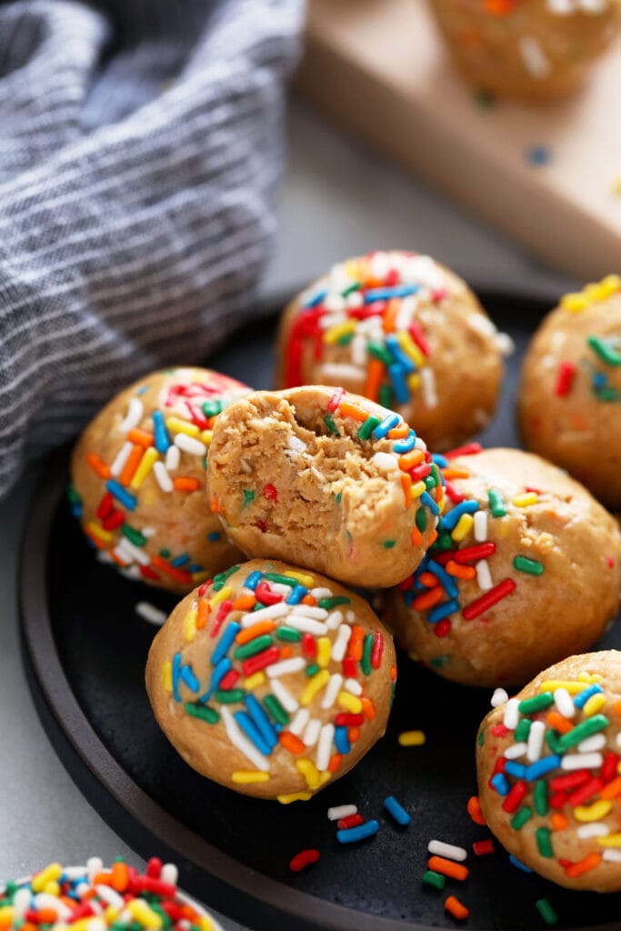 These super flavorful Cake Batter Protein Balls are energy packed from 6 simple ingredients. And no food processor required! cake batter protein balls with a bite taken out of them
