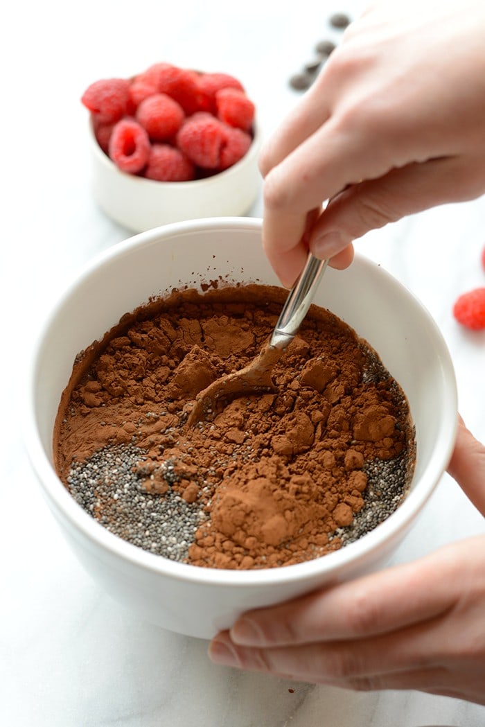 Looking for a dairy-free dessert that the whole family will love? Whip up this easy Chocolate Chia Seed Pudding Recipe with just a few clean ingredients and no refined sugar. Enjoy! chocolate chia seed pudding ingredients being stirred up