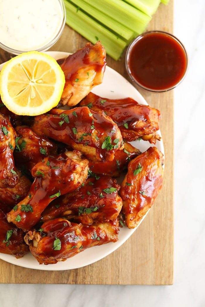 Love chicken wings, but don't want to heat up your whole house? Make our amazing Crockpot Chicken Wings for your next appetizer or snack. Bonus, these crockpot bbq chicken wings aren't fried, so they're on the healthier side! bbq crockpot wings on a plate