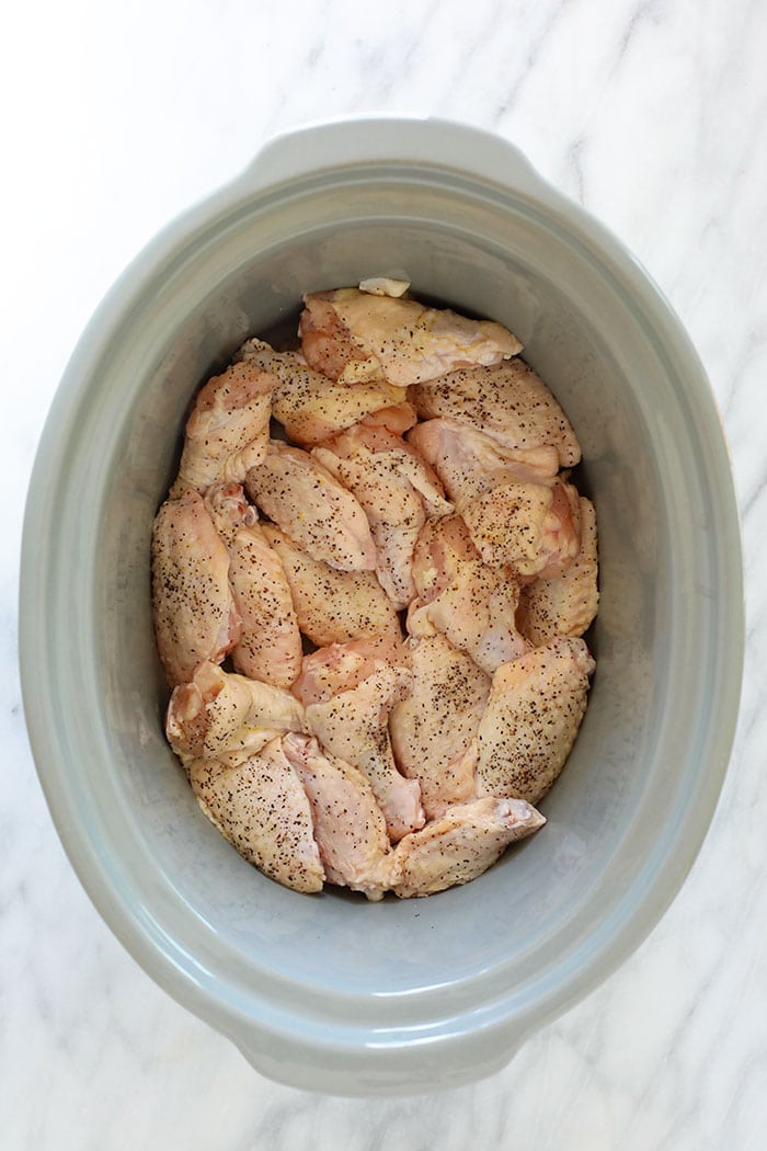 Love chicken wings, but don't want to heat up your whole house? Make our amazing Crockpot Chicken Wings for your next appetizer or snack. Bonus, these crockpot bbq chicken wings aren't fried, so they're on the healthier side! uncooked chicken wings in crockpot