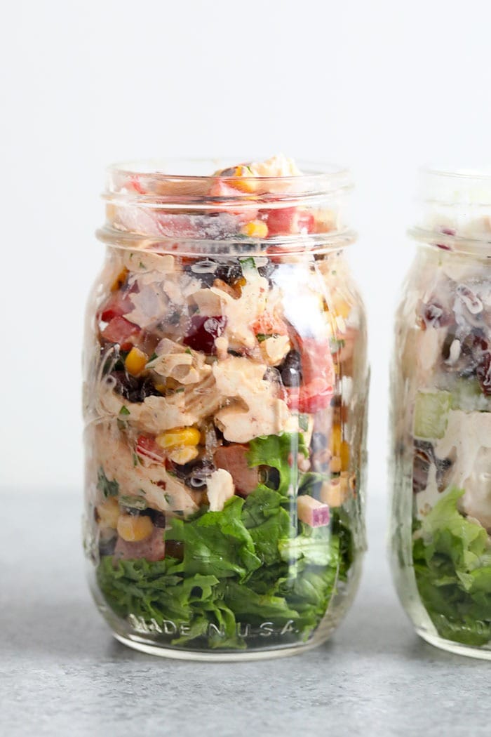 Lunch never tasted so good! Make our Southwest Chicken Salad for a colorful, veggie-packed meal to keep you full all week long. southwest salad in mason jar with lettuce