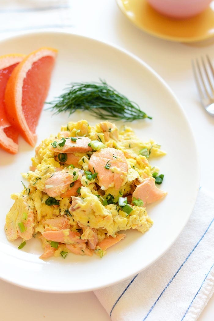 Got leftover salmon? Make this protein-packed dill salmon and eggs scramble that's made with just a few ingredients and seasonal flavors! eggs and salmon on plate