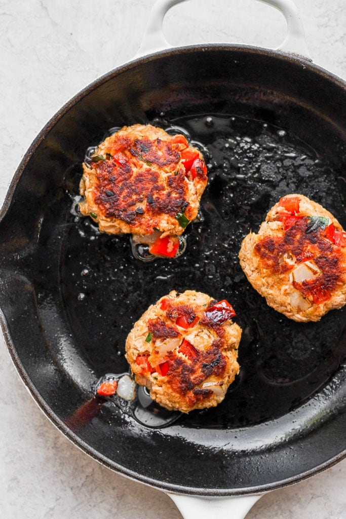 Got leftover salmon to use up? Make these super easy and delicious salmon patties for the perfect leftover meal today! salmon patties pan frying in a skillet