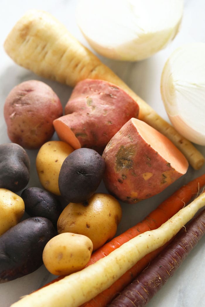 Raw root vegetables on a cutting board.