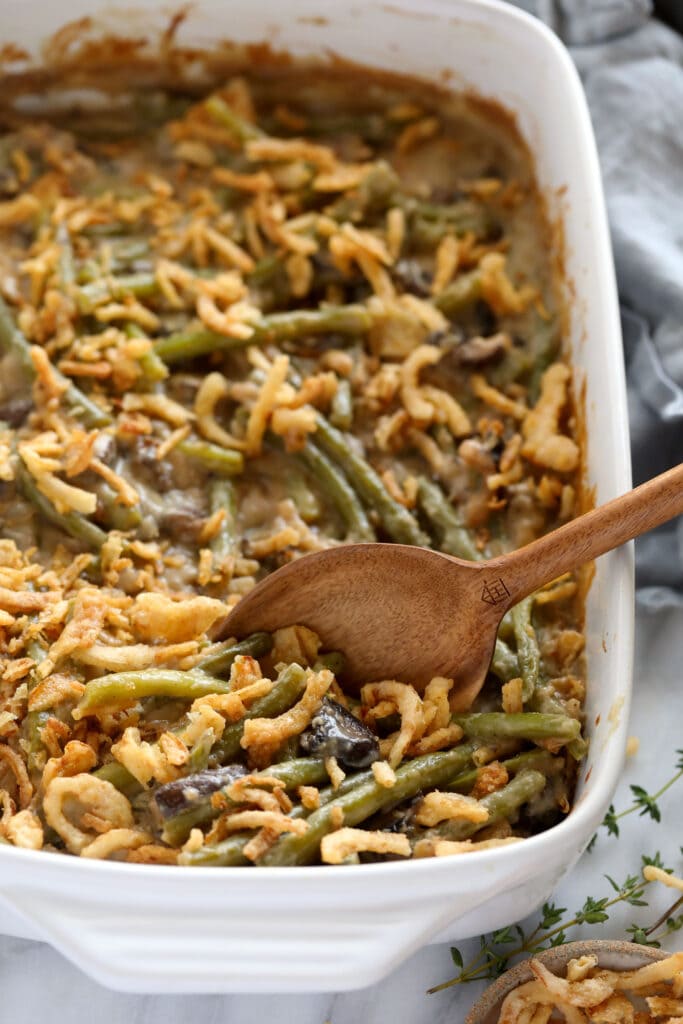 The most delicious, made-from-scratch vegan green bean casserole that tastes just like traditional green bean casserole. casserole with onions and a spoon