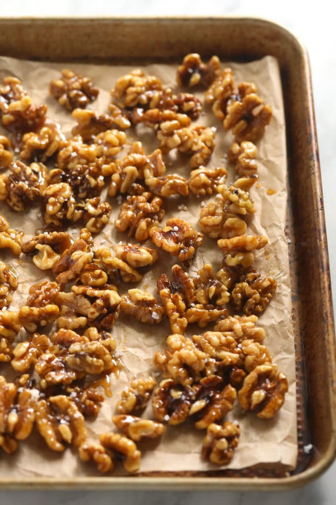 Looking for a last-minute Thanksgiving salad idea? Try our delicious massaged kale, apple, and walnut salad made with goat cheese, dried cherries, and our favorite vinaigrette! candied walnuts on sheet pan