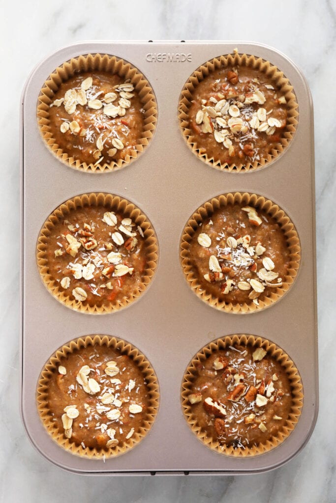 Muffin cups with muffin batter in them.