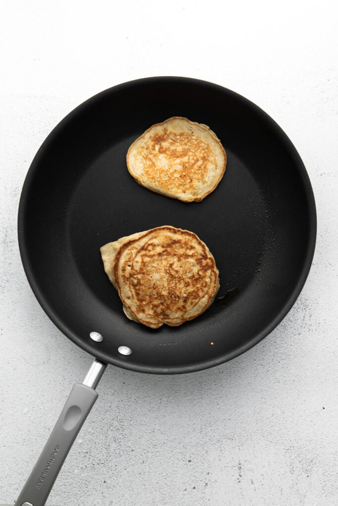 This banana pancake recipe is the ultimate weekend breakfast. Why? These banana pancakes come out super fluffy and they taste heavenly topped with fresh banana and warm maple syrup. cooking pancakes in pan