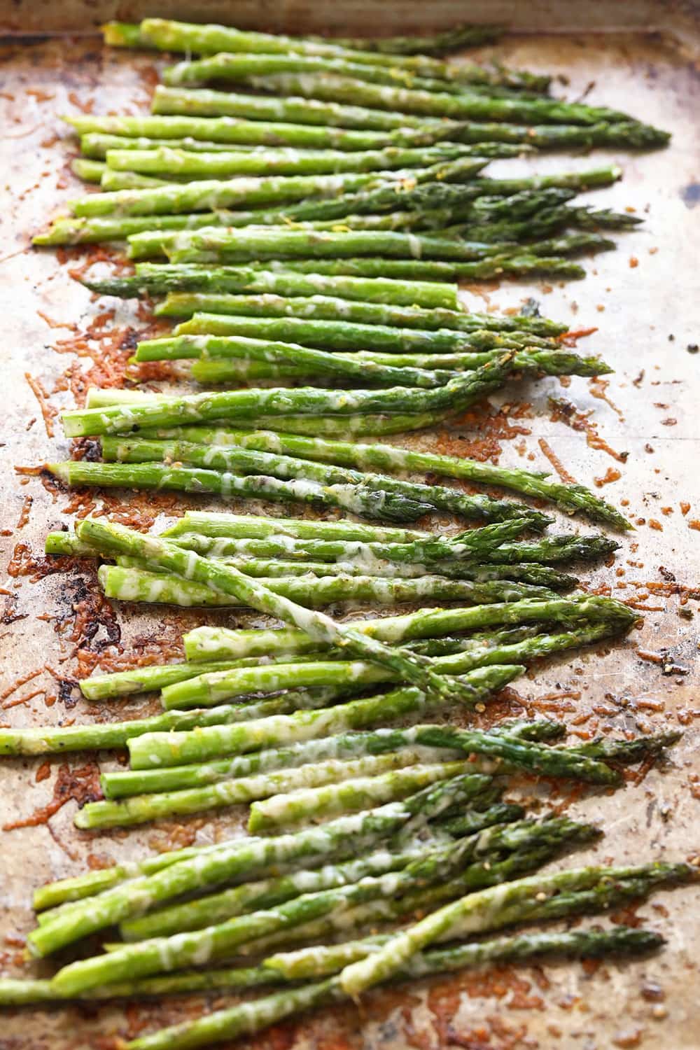 In just 10 minutes you can make perfectly roasted asparagus with parmesan cheese and a little lemon. Asparagus on a baking sheet.