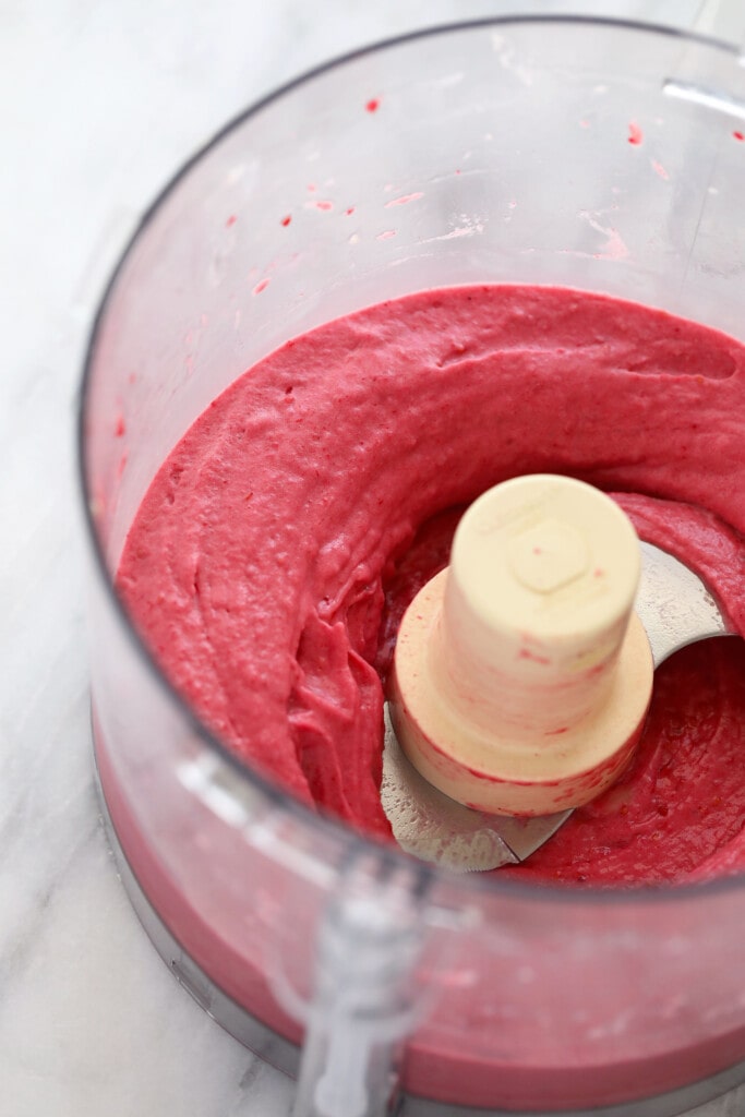 This 5-ingredient Raspberry Chocolate Chunk Nice Cream boasts the same creamy deliciousness of traditional raspberry ice cream, but without all those fillers. raspberry banana nice cream in a food processor blended to perfection
