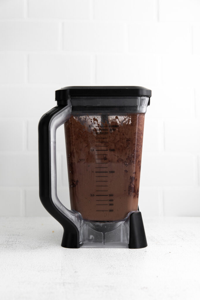 This Chocolate Peanut Butter Banana Smoothie is packed with protein and even has a full serving of greens in it. The best part is, it's healthy and tastes exactly like a peanut butter cup! chocolate smoothie blended in blender