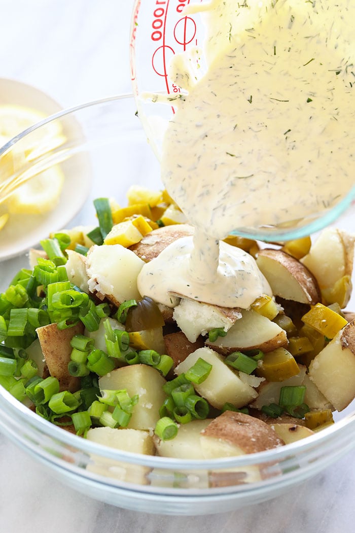 This vegan potato salad is light, bright, and delicious! Not only is this potato salad the perfect summer side, but it's also so easy to make. Pouring sauce over vegan potato salad ingredients