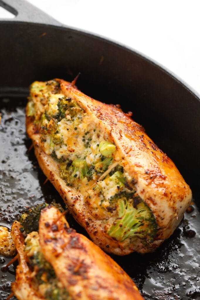 Broccoli and cheese stuffed chicken breast never tasted better! Our super flavorful chicken dry rub and easy broccoli and cheese filling make these stuffed chicken breasts deliciously flavor and protein packed. broccoli and cheese stuffed chicken breasts in a cast iron skillet