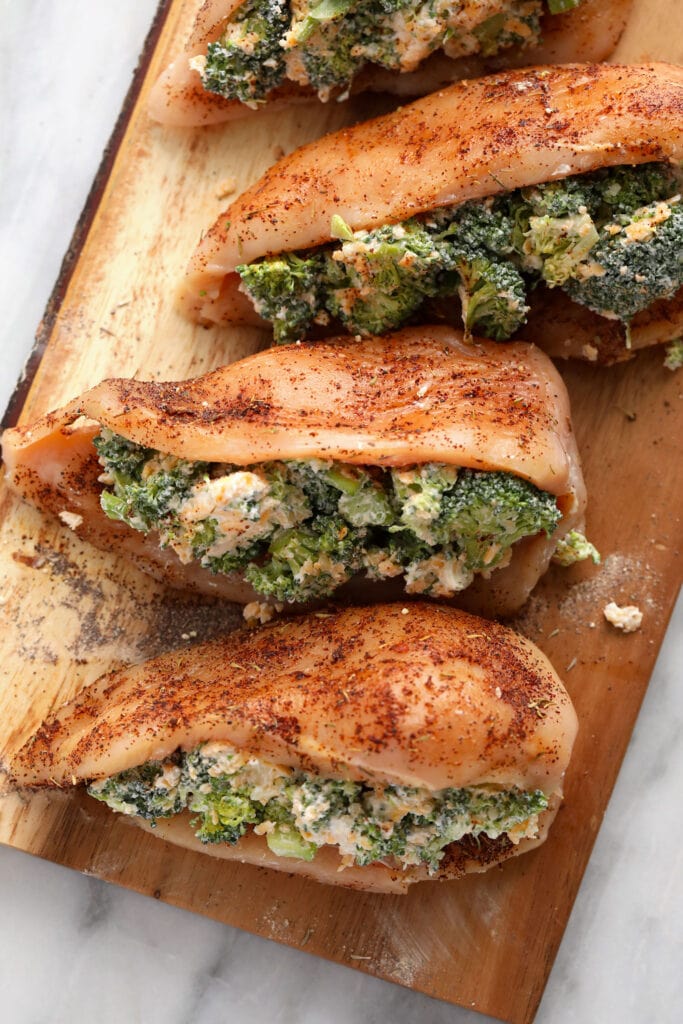Broccoli and cheese stuffed chicken breast never tasted better! Our super flavorful chicken dry rub and easy broccoli and cheese filling make these stuffed chicken breasts deliciously flavor and protein packed. broccoli and cheese stuffed chicken breasts ready to be seared and then baked