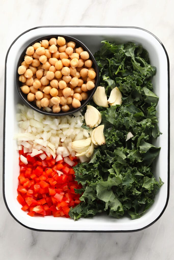 This easy chickpea curry is packed with veggies and a delicious curry sauce. Make it all in one pot in under 30 minutes, and dinner is served! chickpea curry ingredients ready to be added to a dutch oven and sauteed