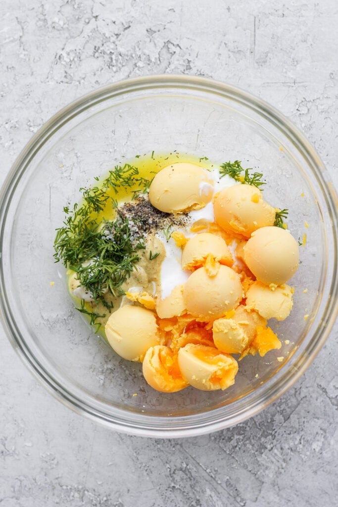 These easy deviled eggs are seriously easy to make with simple ingredients and flavor you'll love. Make a batch of these delicious deviled eggs today! easy deviled egg filling ingredients in a bowl, ready to be mixed